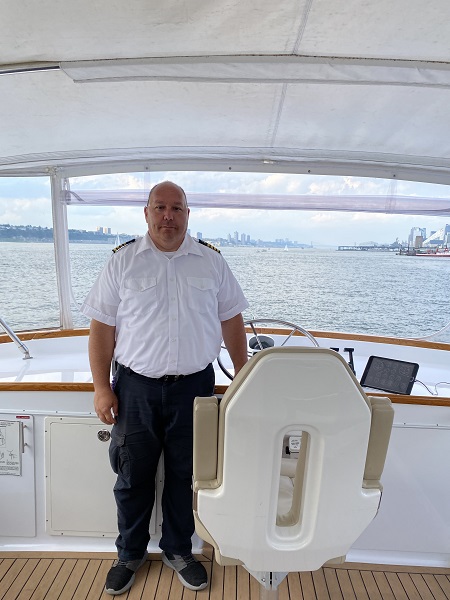 A photo of Captain Mike at the helm of a new york yacht.