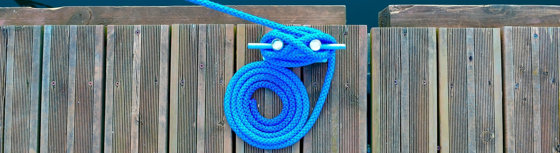 blue line tied to a cleat on a dock.